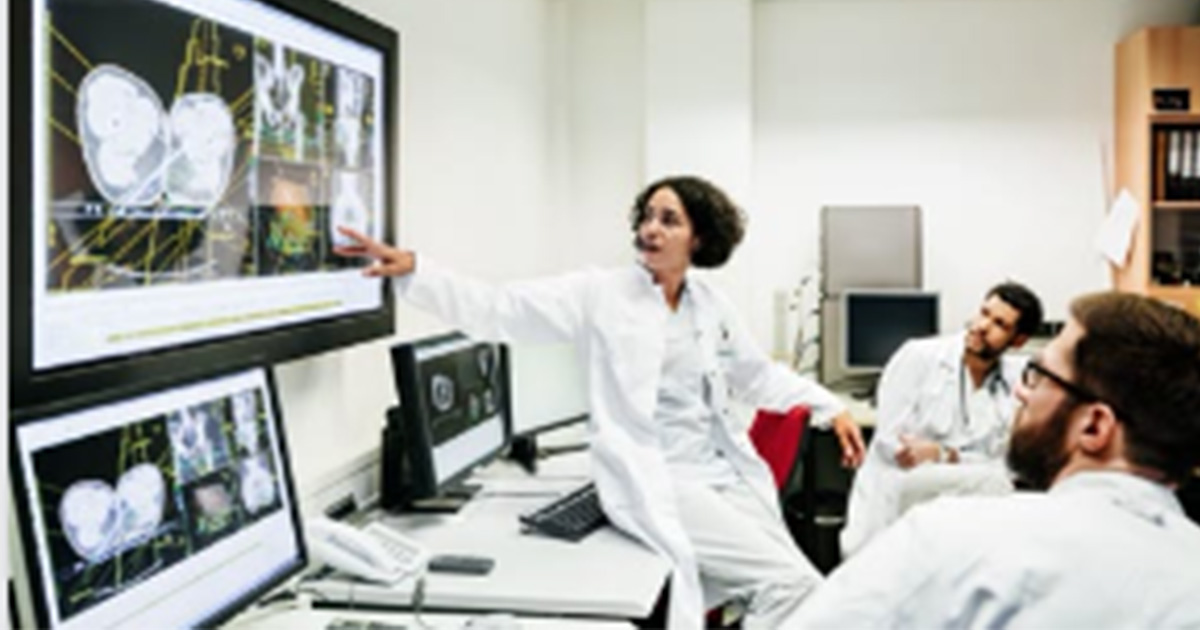 Healthcare workers looking at medical images on a screen