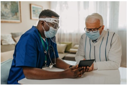 Healthcare worker in mask talking to patient in mask