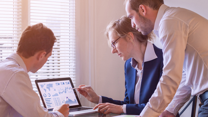 Group of businesspeopl looking at a laptop