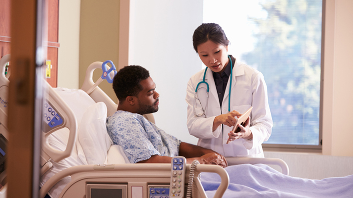 Doctor showing patient tablet.