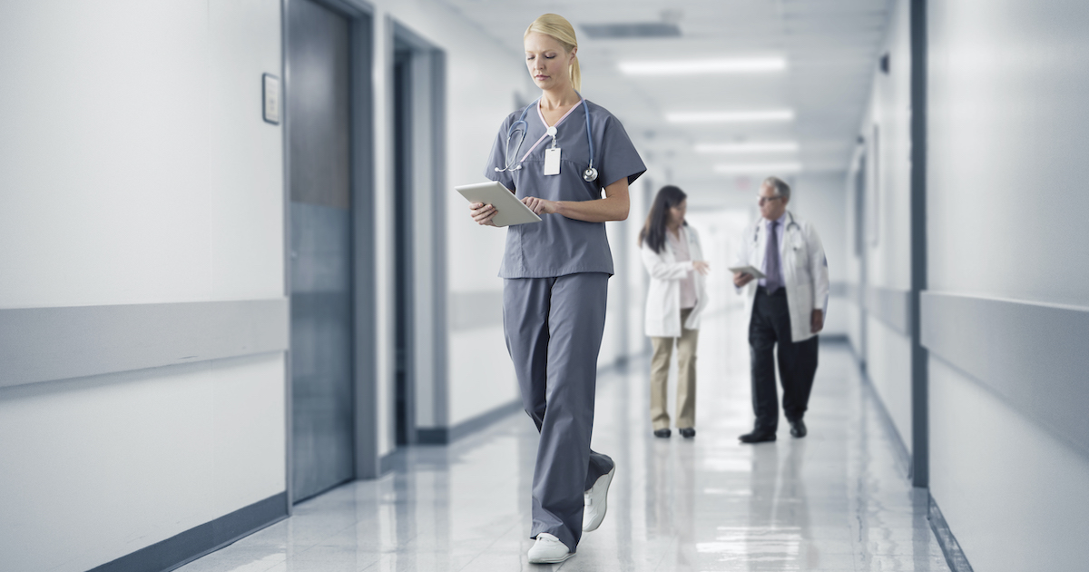 A doctor checking a patient's record on their digital tablet