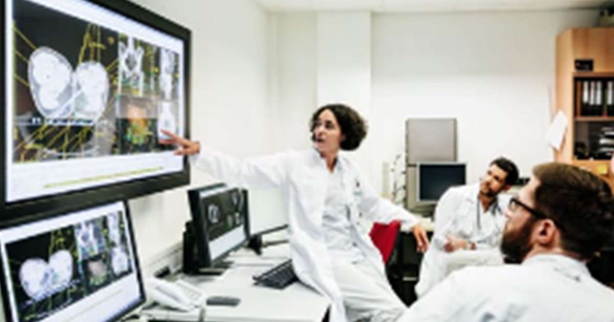 Healthcare worker pointing at medical image on a display screen