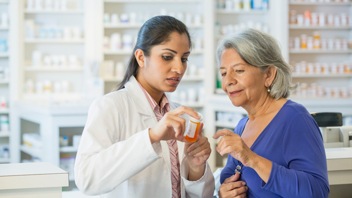 Pharmacist assisting senior customer.