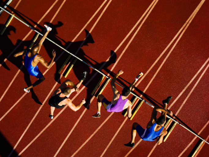 runners jumping hurdles