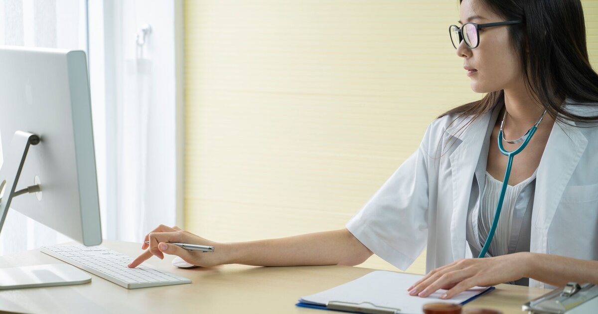 Doctor checking and tracking information on a computer