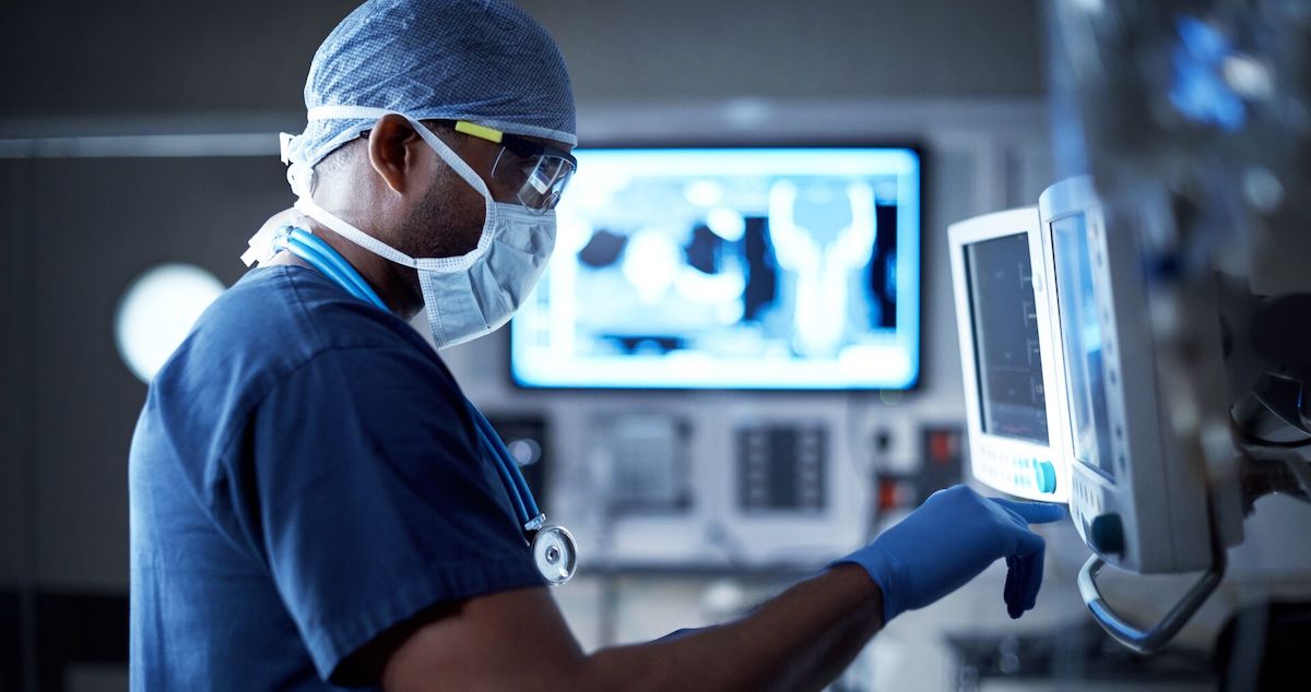 Surgeon consults monitors for data  