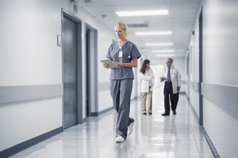 Healthcare worker walking in a hospital with tablet