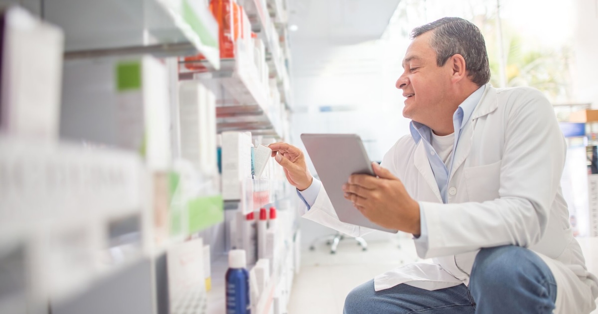 A pharmacist using a digital tablet to do an inventory