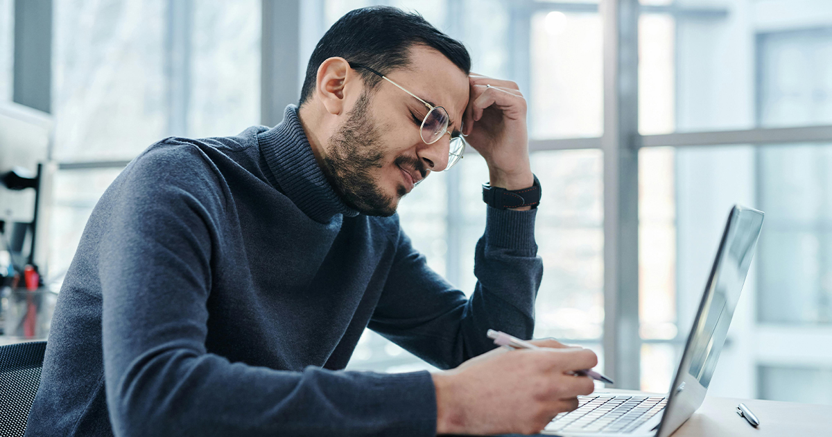 Frustrated man with glasses at a laptop
