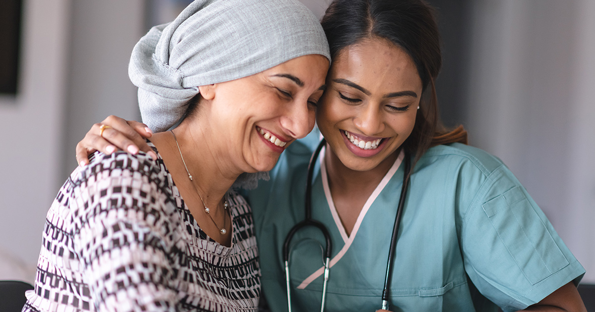 Healthcare worker embracing patient with head wrap