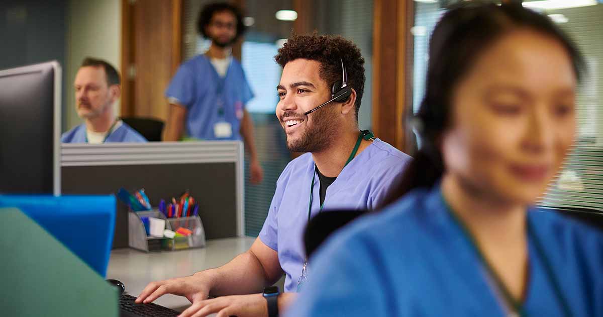 healthcare worker with headset using a computer
