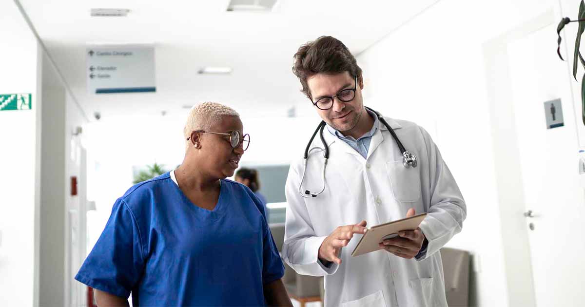 Doctor showing tablet to healthcare worker