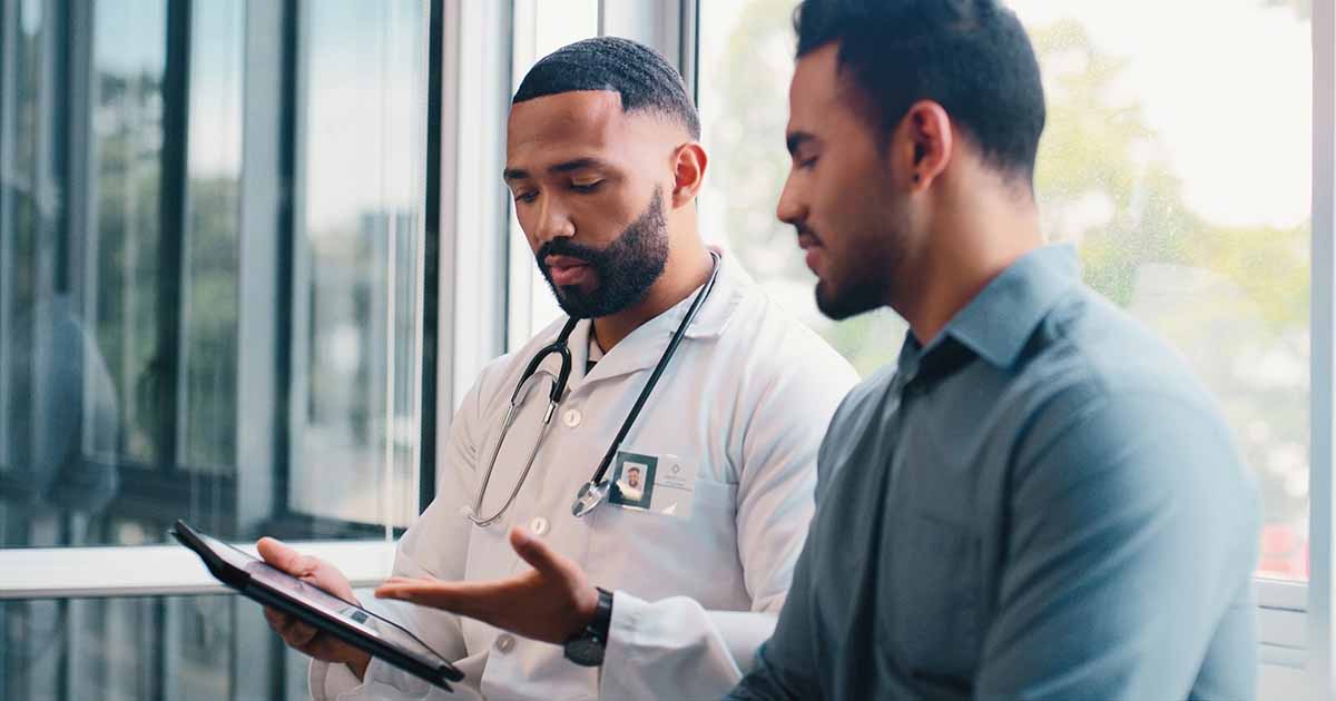 Doctor showing tablet to patient