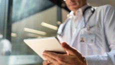 A doctor checking a patient's record on a digital tablet