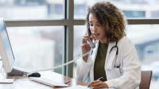 A doctor using a landline to make a phone call