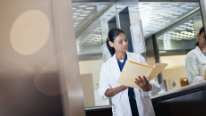 A doctor looking at a patient's paper medical records