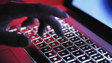 Cybersecurity - hacker's hand at keyboard