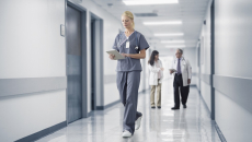 Healthcare worker walking in a hospital with tablet