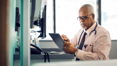 A doctor using an EHR on a tablet