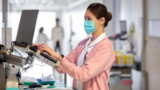 Healthcare professional standing in front of a laptop