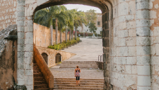 person standing in a city archway on stairs