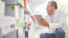 A pharmacist looks at a shelf of medications