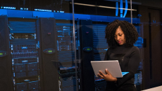 A software engineer standing near a server room
