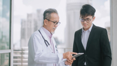 A doctor speaking with a person in a suit.