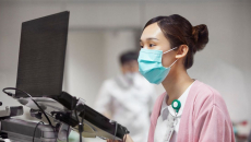 A nurse creates a patient's medical record on a laptop
