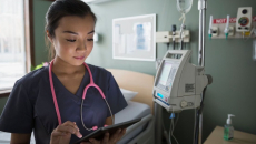 A doctor scrolling through their tablet computer