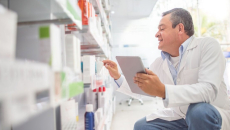 A pharmacist holding a tablet making an inventory
