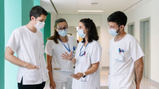 Hospital staff huddled, discussing among themselves