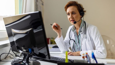 A doctor using a desktop computer for an online consultation