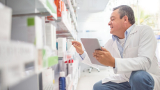 A pharmacist using a digital tablet to do an inventory