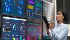 Woman holding a tablet reviews AI data dashboards