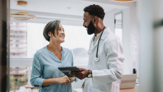 Doctor with tablet talking to patient