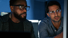 IT security staff discuss threat information in front of a network terminal 