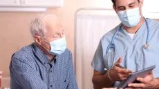 Senior patient reviews information with a doctor during an in-patient visit