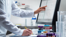 A scientist analysing data from a desktop computer