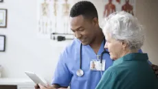 Doctor and veteran look at information on a tablet
