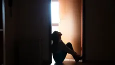 Young woman sits on the floor in a community-based mental health facility