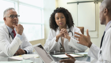 Three doctors discussing among each other in an office meeting