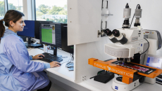 A scientist looks at images on a computer screen as slides are digitally scanned into the system.