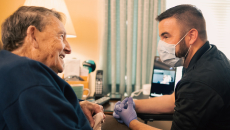 Masked healthcare worker talking to patient