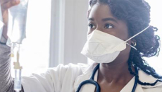 Healthcare worker in mask holding IV drip bag