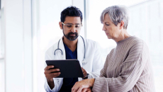 Doctor showing tablet to a patient