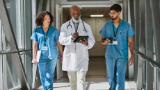 Healthcare workers walking with doctor in hospital hallway