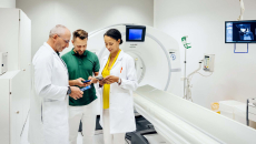 Healthcare workers looking at phones next to MRI machine