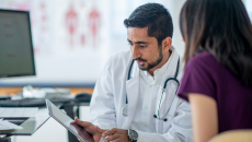 Doctor showing tablet to a patient