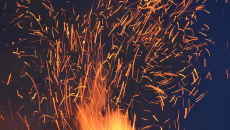 sparks from a fire under a dark sky